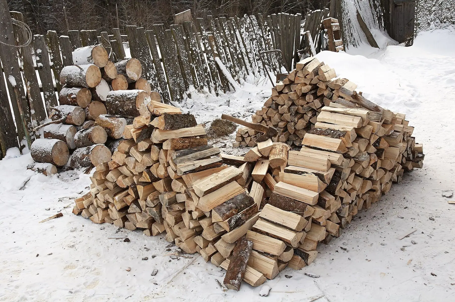Split firewood stacked in neat rows to season over winter