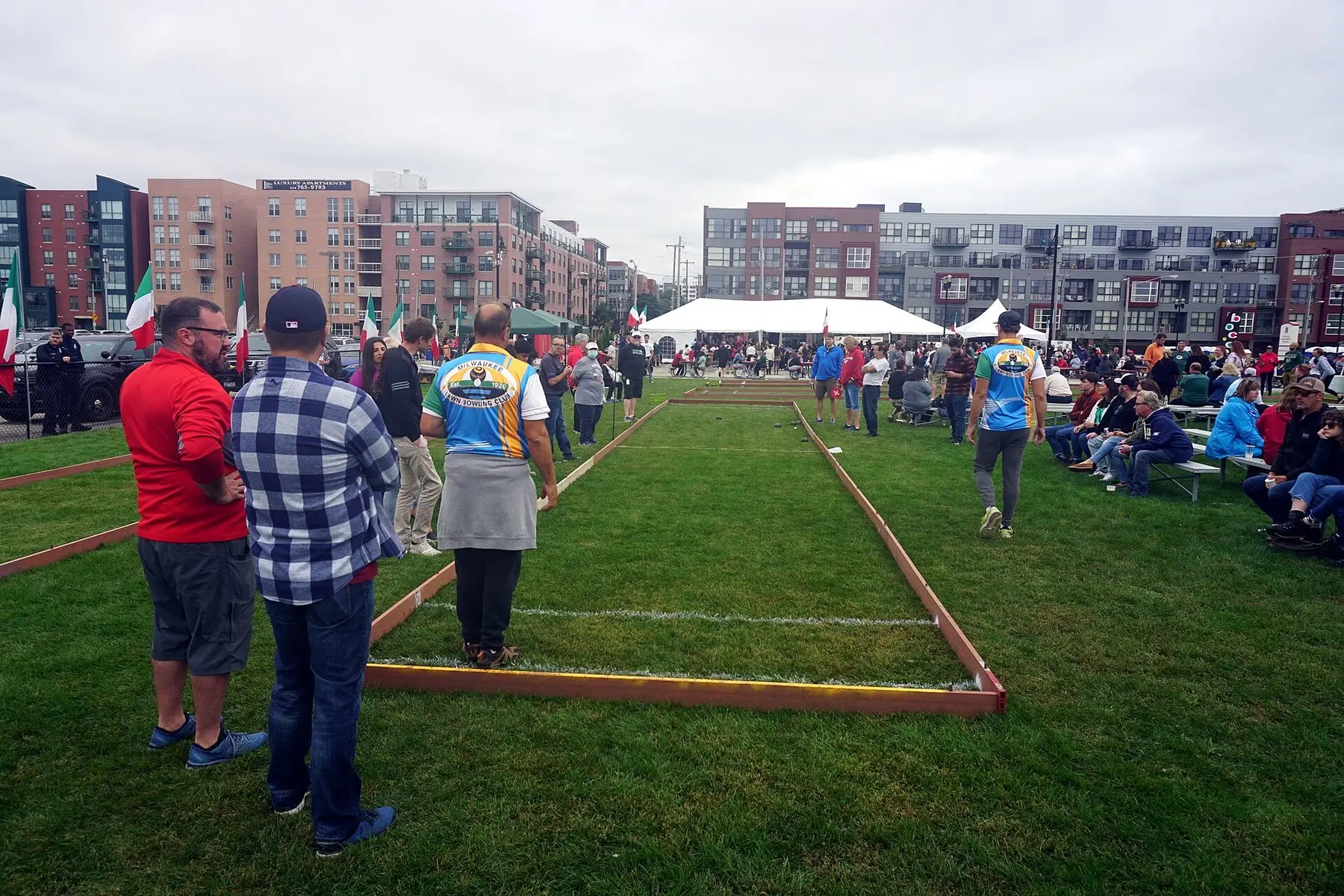 Players on a grass bocce court at an outdoor tournament