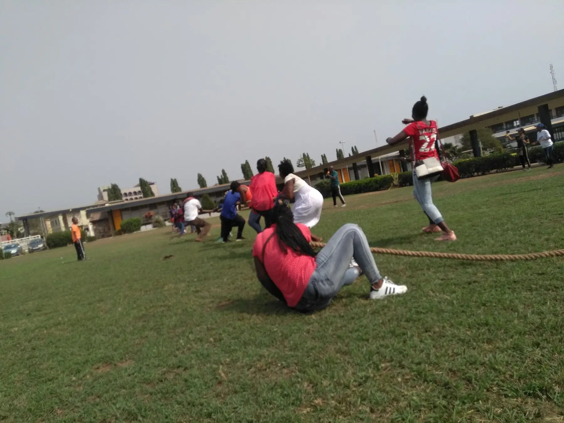Two teams pulling against each other in a tug of war on grass